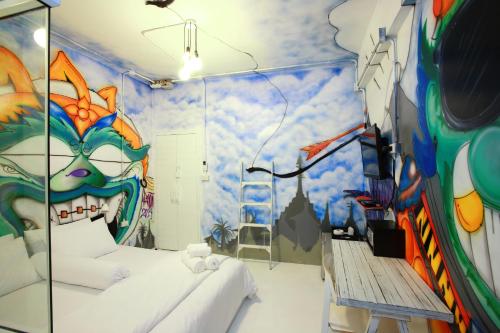 a room with a large mural of aulture at Meroom in Phuket Town