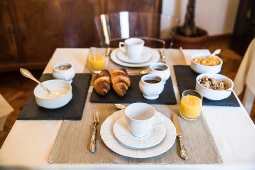 a table topped with plates and cups of coffee and pastries at Villa9centob&b in Castel di Lama