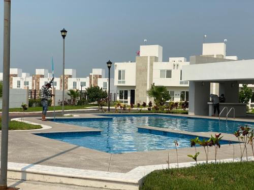 a person is standing in front of a swimming pool at Casa de tus Sueños Dream Lagoons Veracruz in Veracruz