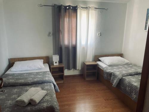 a small room with two beds and a window at Pansion Luka in Međugorje