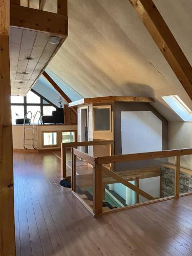 an attic room with a wooden floor and wooden beams at Traumscheune mit Pool, Kamin und privatem Spa in Linnich