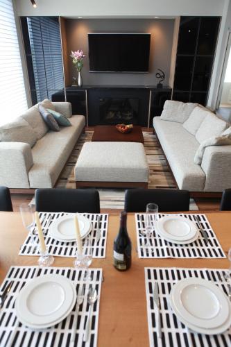 a living room with a table with white plates on it at hirafu188 in Kutchan