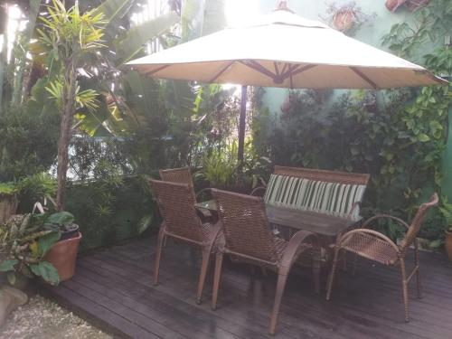 a wooden deck with a table and chairs and an umbrella at Pousada Ares do Sul in Penha