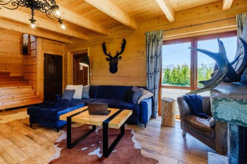 a living room with a blue couch and a table at Dziadkowka in Gliczarów