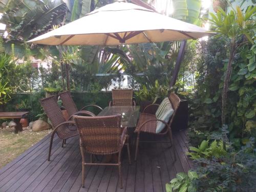 a patio with a table and chairs and an umbrella at Pousada Ares do Sul in Penha