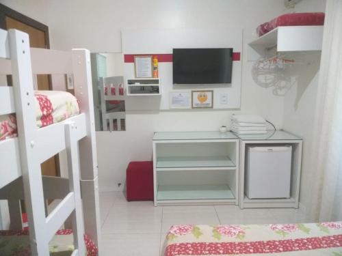 a small room with a desk and a bunk bed at Pousada Ares do Sul in Penha