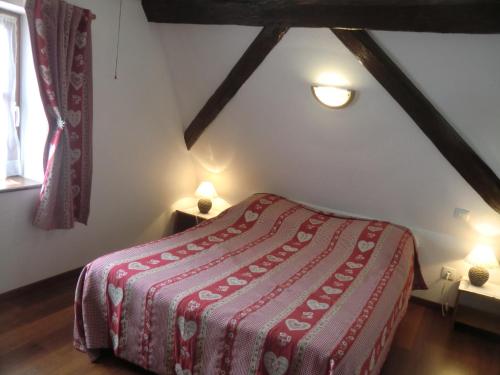 een slaapkamer met een bed met een rode deken bij Gite Gewurztraminer in Colmar