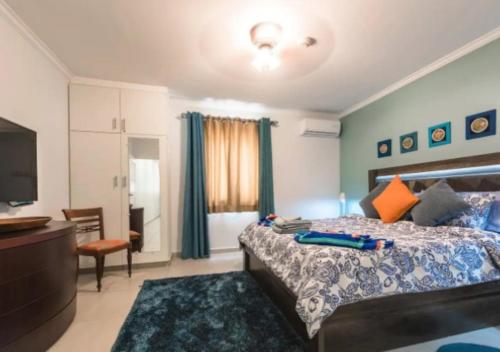 une chambre avec un grand lit et une télévision dans l'établissement Apartamento Vacacional en Aruba Cerca a la Playa, à Palm-Eagle Beach