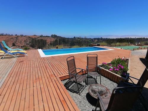 Una terraza con dos sillas y una piscina. en Casa COSMOS golf., en Algarrobo