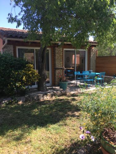 a house with a table and chairs in the yard at La chambre haute, son jardin, et, son SPA in Nîmes