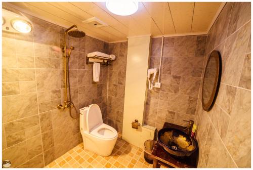 a bathroom with a toilet and a shower at Yi's Hostel in Shangri-La