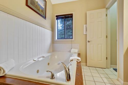eine weiße Badewanne im Bad mit Fenster in der Unterkunft 212 Pointes North Inn in Charlevoix