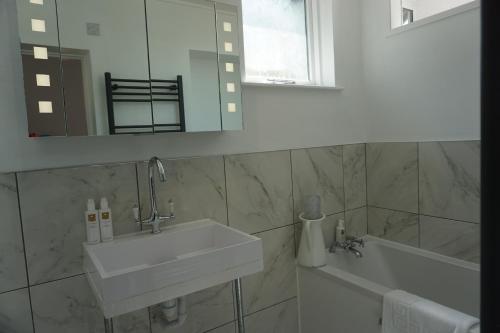 a bathroom with a sink and a tub and a mirror at Lake View Country House in Grasmere