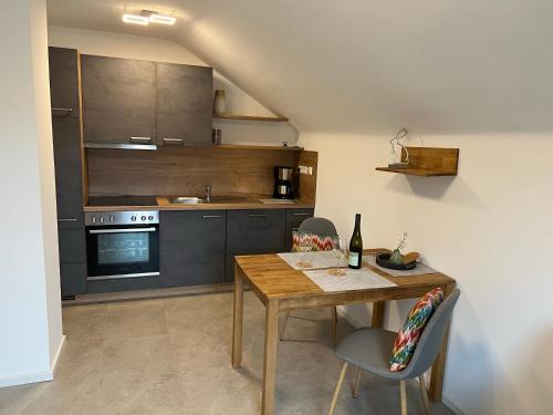 a kitchen with a wooden table and chairs in a room at Ferienweingut Wissing Wohnung Frieda in Gleiszellen-Gleishorbach