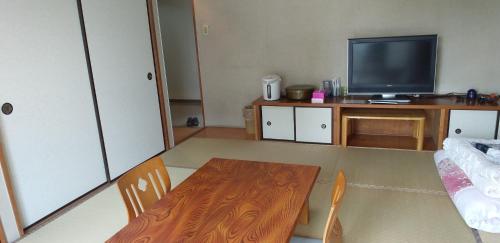 a living room with a table and a television at INARIRYOKAN - Vacation STAY 47680v in Sayama