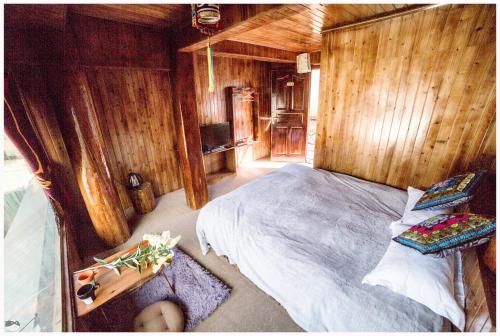 a bedroom with a bed in a wooden room at Yi's Hostel in Shangri-La