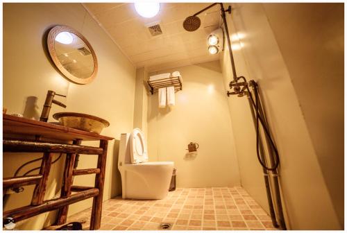 a bathroom with a shower and a toilet in it at Yi's Hostel in Shangri-La