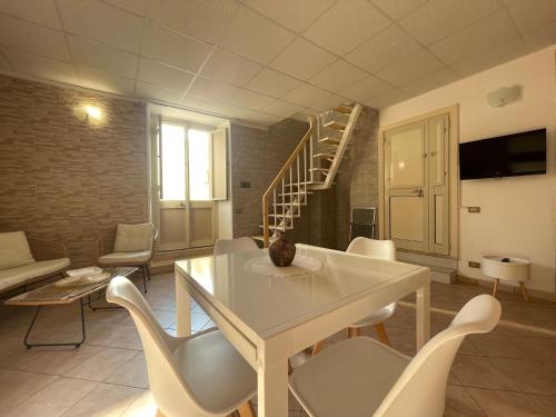 un soggiorno con tavolo, sedie e scala di Casa Borgomonte a Otranto