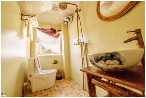 a bathroom with a bowl sink and a toilet at Yi's Hostel in Shangri-La