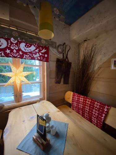 a room with a bed with a table and a window at Karczma Kubalonka in Istebna