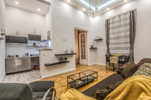 a living room with a couch and a kitchen at SemmiHome Budapest Semmelweis Street in Budapest