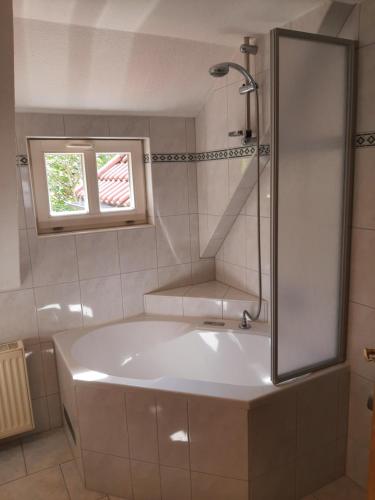 a white tub in a bathroom with a window at Garni-Pension Andrä in Schierke