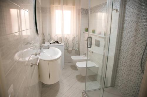 e bagno con servizi igienici, lavandino e doccia. di Sweet House Taormina a Taormina