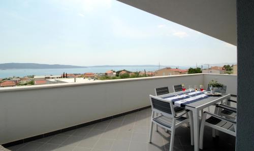 a balcony with a table and a view of the water at Apartman Cicibella in Kaštela