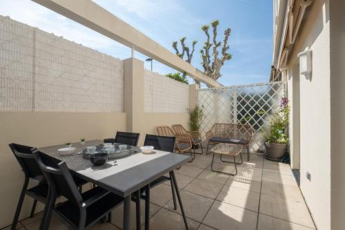 un patio avec une table et des chaises sur un balcon dans l'établissement  Idéal famille  Appartement tout confort dans résidence avec piscine !, à Cannes