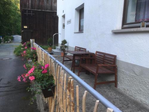 two benches and a table outside of a building with flowers at Ferienwohnung Schlossberg 3 in Wirsberg