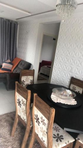 ein Esszimmer mit einem Tisch und Stühlen sowie ein Schlafzimmer in der Unterkunft brisas da maré in Passo de Torres