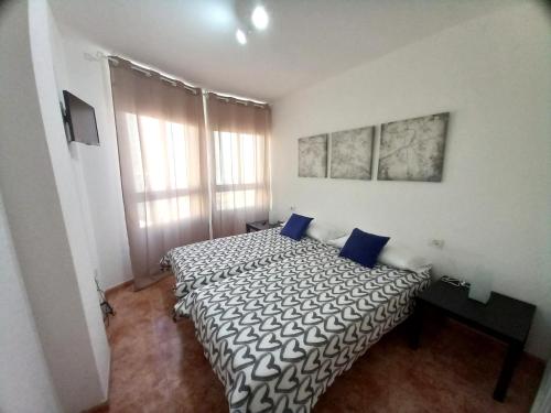 een slaapkamer met 2 bedden en blauwe kussens bij Apartamentos Medano - Esmeralda Medano in El Médano