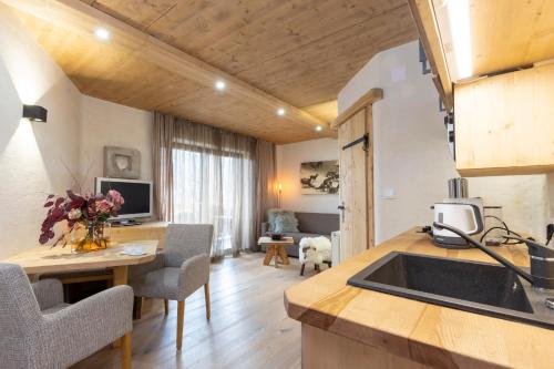 eine Küche und ein Wohnzimmer mit einem Waschbecken und einem Tisch in der Unterkunft Appartementhaus Anka in Seefeld in Tirol