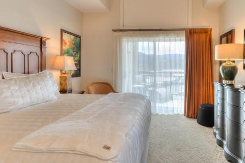 a bedroom with a bed and a large window at RiverStone Condo Resort & Spa in Pigeon Forge