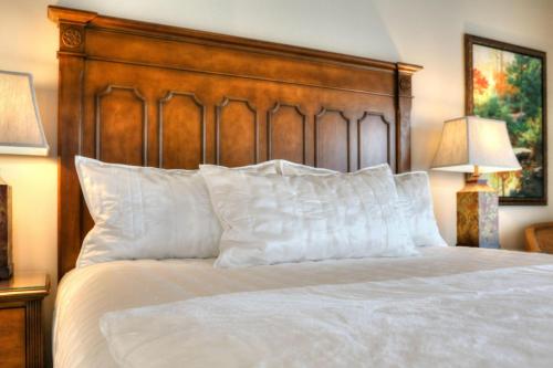 a bed with white pillows and a wooden headboard at RiverStone Condo Resort & Spa in Pigeon Forge