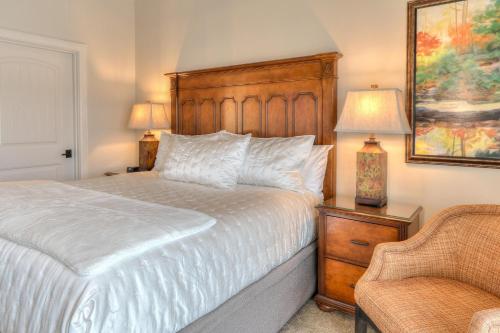 a bedroom with a white bed and a chair at RiverStone Condo Resort & Spa in Pigeon Forge