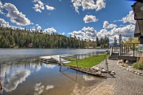 a dock on a lake with trees in the background at A Contemporary Dream Lakefront Rathdrum Oasis! in Rathdrum