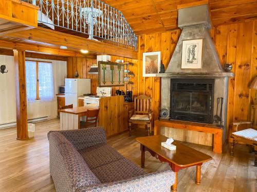 a living room with a couch and a fireplace at La Sapinette in Val-David