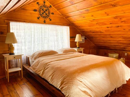 sypialnia z dużym łóżkiem w drewnianym suficie w obiekcie La Sapinette w mieście Val-David
