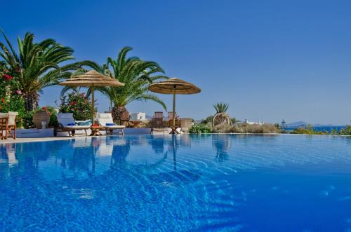 a large swimming pool with umbrellas and chairs at Kavos Hotel Naxos in Agios Prokopios