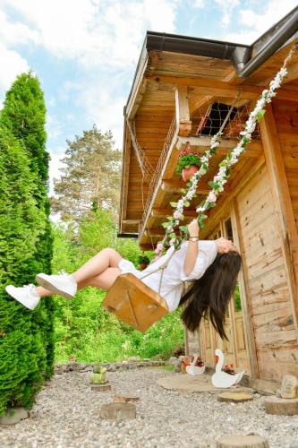 a woman is hanging off of a house at Drinska Villa Cabin in Perućac