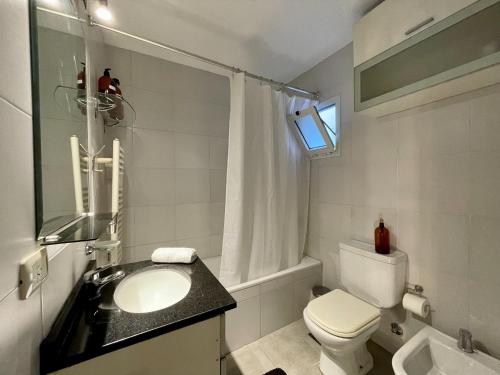 a bathroom with a sink and a toilet and a window at Premium loft dúplex con terraza in Cordoba