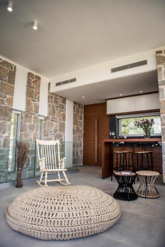 a living room with a chair and a table at VARKO LUXURY SUITES in Paleros