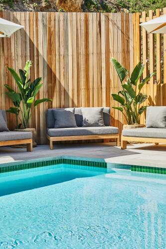 a swimming pool with two couches next to a wooden fence at Hotel June Malibu in Malibu