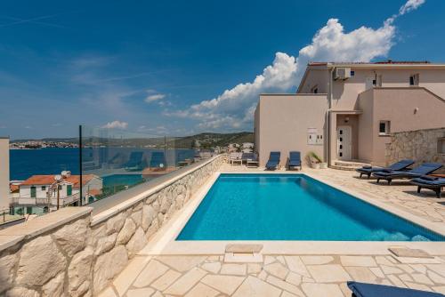a villa with a swimming pool and a view of the ocean at Villa Mona Apartments in Ražanj