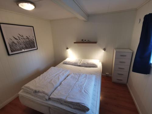 a bedroom with a bed and a lamp on the wall at Reipå Camping in Reipå