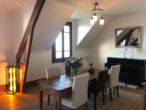 une salle à manger avec une table et un piano dans l'établissement La Madelon Front de mer, à Villers-sur-Mer