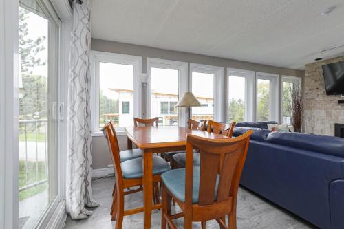 a living room with a table and chairs and a blue couch at Condo at Blue Mountain on Ski Run Close to Village in Blue Mountains