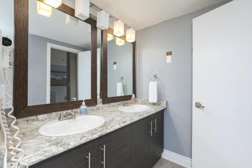 Un baño con dos lavabos y un espejo. en Condo at Blue Mountain on Ski Run Close to Village, en Blue Mountains