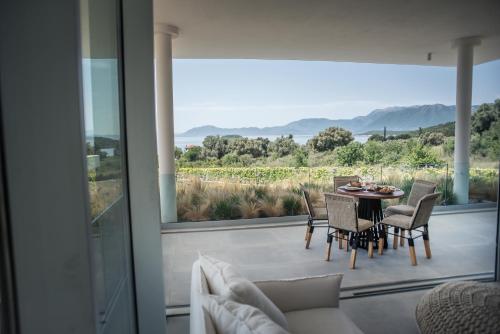a patio with a table and chairs and a large window at VARKO LUXURY SUITES in Paleros